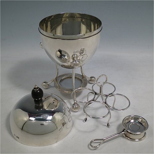 A rare Antique Edwardian Sterling Silver egg coddler, having a plain round body, with lift-off lid and wooden finial, sitting in a wire-work frame with ball terminals, an interior egg-holder for four eggs, and an original burner, all sitting on four ball feet. Made by Mappin & Webb of Sheffield in 1907. The dimensions of this fine hand-made antique silver egg coddler are height 23 cms (9 inches), diameter 11 cms (4.3 inches), and it weighs approx. 510g (16.5 troy ounces).