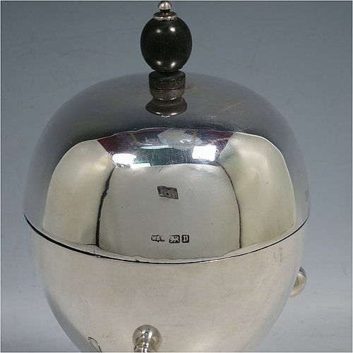 A rare Antique Edwardian Sterling Silver egg coddler, having a plain round body, with lift-off lid and wooden finial, sitting in a wire-work frame with ball terminals, an interior egg-holder for four eggs, and an original burner, all sitting on four ball feet. Made by Mappin & Webb of Sheffield in 1907. The dimensions of this fine hand-made antique silver egg coddler are height 23 cms (9 inches), diameter 11 cms (4.3 inches), and it weighs approx. 510g (16.5 troy ounces).