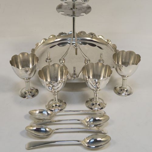A pretty Sterling Silver egg cruet set, having a plain round body with a scalloped border, four plain round egg cups, a loop handle and holder with four original egg spoons, and all sitting on four ball feet. This elegant silver egg cruet set was all made by John Batt of Sheffield in 1924. The dimensions of this fine hand-made silver egg cruet set are height 18.5 cms (7.25 inches), diameter of main body 14.5 cms (5.75 inches), with a total weight of approx. 543g (17.5 troy ounces).