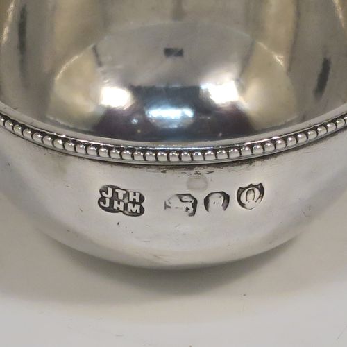 An elegant Antique Victorian Sterling Silver egg cruet or holder set, having three attached plain round bodied egg cups with applied bead-edged borders, and a ring handle above. This handsome antique egg holder was made by Heath and Middleton of London in 1889. The dimensions of this fine hand-made silver egg holder are height 10 cms (4 inches), width 10 cms (4 inches), and it weighs approx. 82g (2.6 troy ounces).