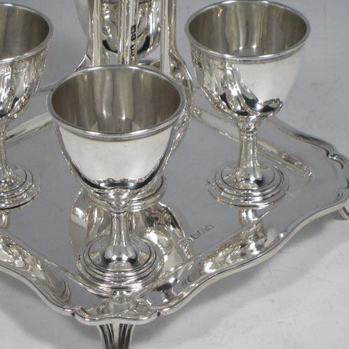 Antique Edwardian sterling silver egg cruet set, having four plain round egg cups sitting on pedestal feet, four plain egg spoons, and a cast loop handle attached to a square base with shaped reeded border sitting on four flange feet. Made by Henry Atkins of Sheffield in 1902. The spoons are made by Jackson & Fullerton of London in 1902. The dimensions of this fine hand-made silver egg cruet set are height 18 cms (7 inches), the base is 14 cms (5.5 inches) square and the total weight is approx. 647g (21 troy ounces).