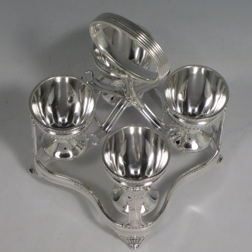 Sterling silver egg cruet set, having four round egg cups, sitting inside a frame with gadroon, shell, and anthemion leaf decoration, and a reeded loop handle, all sitting on four flange feet. Made by George Hancock of Sheffield in 1915. Please note that there are no spoons with this stand. The dimensions of this fine hand-made silver egg cruet set are height 16 cms (6.25 inches), the base is 11 cms (4.3 inches) square and the total weight is approx. 483g (15.6 troy ounces).