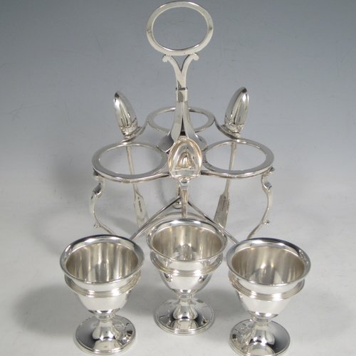 Antique Victorian sterling silver egg cruet set, having three removable plain round egg cups, and loop handle, all in a frame stand sitting on three scroll cushioned feet. The silver stand and egg cups are all made by Samuel Whitford of London in 1839, whilst the four spoons are in silver-plate. The dimensions of this fine hand-made silver egg cruet set are height 20 cms (8 inches), width 13.5 cms (5.3 inches), with a total weight of approx. 381g (12.3 troy ounces).