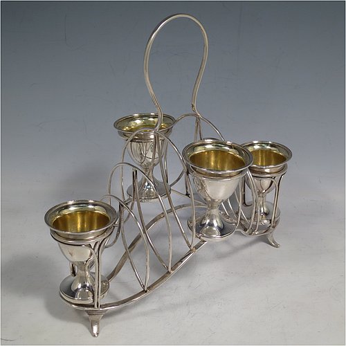 An Antique Georgian Sterling Silver egg cruet set, having four removable plain round egg cups with reeded borders and gold-gilt interiors, and all sitting in a wire-work frame toast-rack stand with four flange feet, and a looped carrying handle. Made by William Abdy of London in 1801. The dimensions of this fine hand-made antique silver egg cruet and toast set are height 22 cms (8.75 inches), length 23 cms (9 inches), width 14 cms (5.5 inches), with a total weight of approx. 500g (16 troy ounces).    
