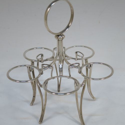 A very handsome Antique Victorian Sterling Silver egg cruet set, having five removable plain round egg cups with reeded borders and gold-gilt interiors, all sitting in a plain wire-work frame stand with five feet, together with five matching plain Old English pattern spoons. The cruet frame and egg cups made by the Barnard Brothers of London in 1859, and the spoons made by James Dixon and Sons of Sheffield in 1922. The dimensions of this fine hand-made antique silver egg cruet set are height 18 cms (7 inches), width 15 cms (6 inches), with a total weight of approx. 477g (15.4 troy ounces).