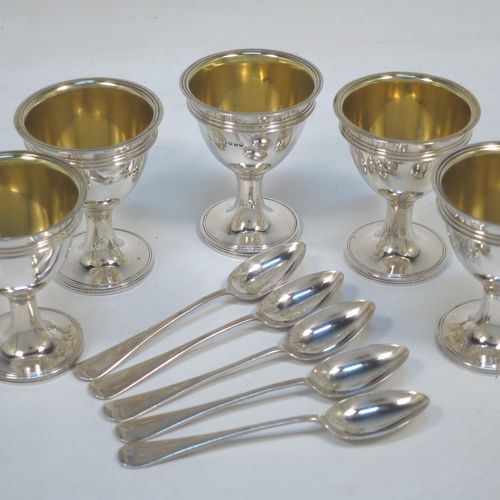 A very handsome Antique Victorian Sterling Silver egg cruet set, having five removable plain round egg cups with reeded borders and gold-gilt interiors, all sitting in a plain wire-work frame stand with five feet, together with five matching plain Old English pattern spoons. The cruet frame and egg cups made by the Barnard Brothers of London in 1859, and the spoons made by James Dixon and Sons of Sheffield in 1922. The dimensions of this fine hand-made antique silver egg cruet set are height 18 cms (7 inches), width 15 cms (6 inches), with a total weight of approx. 477g (15.4 troy ounces).