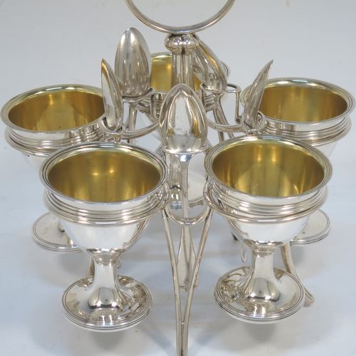 A very handsome Antique Victorian Sterling Silver egg cruet set, having five removable plain round egg cups with reeded borders and gold-gilt interiors, all sitting in a plain wire-work frame stand with five feet, together with five matching plain Old English pattern spoons. The cruet frame and egg cups made by the Barnard Brothers of London in 1859, and the spoons made by James Dixon and Sons of Sheffield in 1922. The dimensions of this fine hand-made antique silver egg cruet set are height 18 cms (7 inches), width 15 cms (6 inches), with a total weight of approx. 477g (15.4 troy ounces).