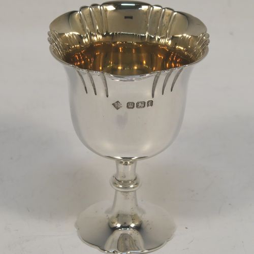 A very pretty Antique Victorian Sterling Silver egg cruet set with hand-chased fluted and shell decoration, having egg cups with gold-gilt interiors, and a cast shell and scroll loop handle attached to a round base sitting on four cast scrolled feet. This beautiful antique silver egg cruet set was made by Martin Hall and Co., of Sheffield in 1892 / 1898 (two of the egg cups are from 1892). The dimensions of this fine hand-made silver egg cruet set are height 18 cms (7 inches), the base is 15 cms (6 inches) in diameter, and the total weight is approx. 505g (16.3 troy ounces).