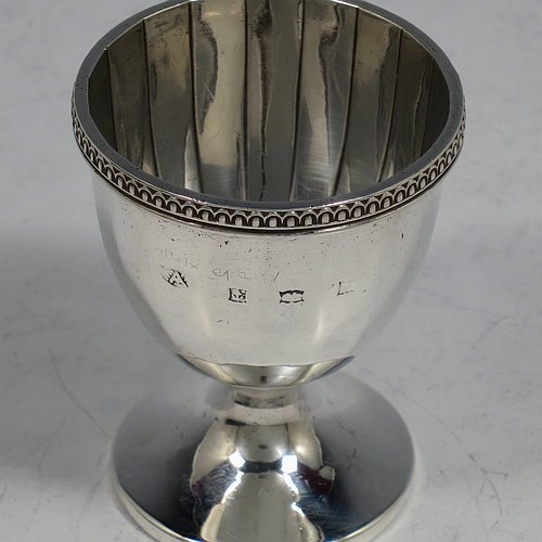 A Sterling Silver egg cup and spoon christening set, having a hand-chased panelled round egg cup, with an applied bead border, and a plain Old English pattern spoon. All fitted in their original cream satin and black velvet-lined presentation box. Made by the Adie Brothers of Birmingham in 1974. The dimensions of this fine hand-made silver egg cup & spoon christening set are length of spoon 11.5 cms (4.5 inches), height of egg cup 6 cms (2.3 inches), and the total weight is approx. 81g (2.6 troy ounce).   