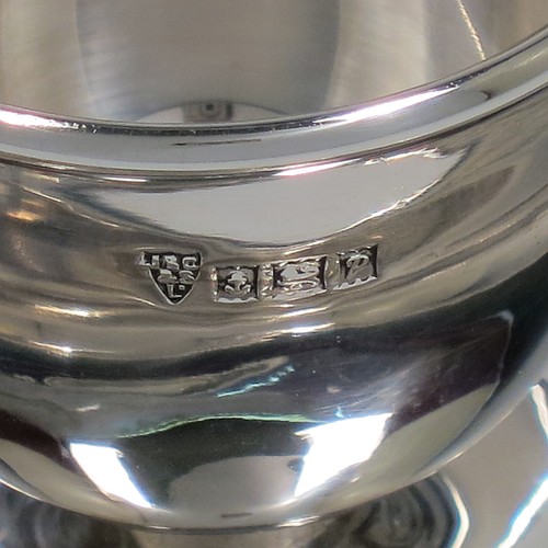 A Sterling Silver egg cup, having a plain round body with tapering sides, with an attached plain round plate with curved border, and sitting on a flat base. Made J. B. Chatterly of Birmingham in 1964. The dimensions of this fine hand-made silver egg cup are height 5 cms (2 inches), diameter 10 cms (4 inches), and it weighs approx. 87g (2.8 troy ounces).