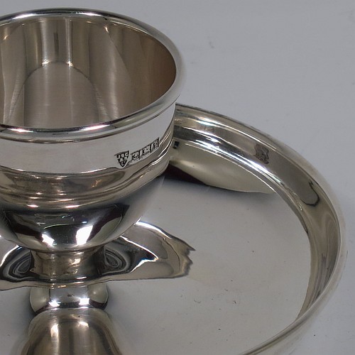 A Sterling Silver egg cup, having a plain round body with tapering sides, with an attached plain round plate with curved border, and sitting on a flat base. Made J. B. Chatterly of Birmingham in 1964. The dimensions of this fine hand-made silver egg cup are height 5 cms (2 inches), diameter 10 cms (4 inches), and it weighs approx. 87g (2.8 troy ounces).