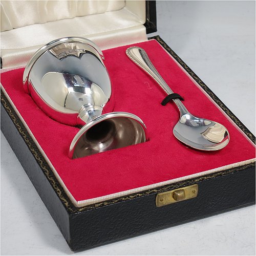 A Sterling Silver christening set, having an egg cup with gold-gilt interior, and a spoon with a rope-twist border. All fitted in their original cream satin and red velvet-lined presentation box. Made in Birmingham in 1974. The dimensions of this fine hand-made silver christening set are length of spoon 11 cms (4.3 inches), height of egg cup 6.5 cms (2.5 inches), and the total weight is approx. 36g (2 troy ounces).    