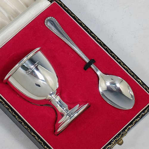A Sterling Silver christening set, having an egg cup with gold-gilt interior, and a spoon with a rope-twist border. All fitted in their original cream satin and red velvet-lined presentation box. Made in Birmingham in 1974. The dimensions of this fine hand-made silver christening set are length of spoon 11 cms (4.3 inches), height of egg cup 6.5 cms (2.5 inches), and the total weight is approx. 36g (2 troy ounces).    
