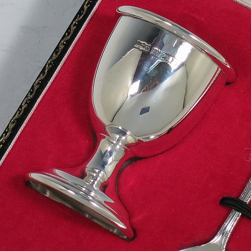 A Sterling Silver christening set, having an egg cup with gold-gilt interior, and a spoon with a rope-twist border. All fitted in their original cream satin and red velvet-lined presentation box. Made in Birmingham in 1974. The dimensions of this fine hand-made silver christening set are length of spoon 11 cms (4.3 inches), height of egg cup 6.5 cms (2.5 inches), and the total weight is approx. 36g (2 troy ounces).    
