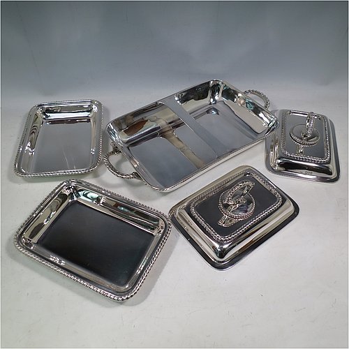 An Antique Edwardian Sterling Silver pair of entree dishes with covers on a silver-plated warming stand for hot water, having rectangular bodies with applied gadroon borders, and with removable bayonet-fit handles. All in original condition and made by Goldsmiths & Silversmiths of London in 1902. The dimensions of this fine pair of hand-made antique silver entree dishes on a silver plated warming stand are length (inc. handles) 34 cms (13.5 inches), width 20 cms (8 inches), height 12 cms (5 inches), and the entree dishes weigh approx. 1,721g (55.5 troy ounces).
