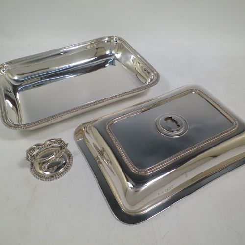A handsome Antique Sterling Silver entree dish with cover, having a rectangular body with rounded corners and applied straight gadroon borders, a cast bayonet-fit removable asparagus style loop handle, and sitting on a flat base. Made by Carrington and Co., of London in 1912. The dimensions of this fine hand-made antique silver entree dish and cover are length 28 cms (11 inches), height including handle 11 cms (4.5 inches), width 20 cms (8 inches), and with a total weight of approx. 1,540g (49.7 troy ounces).