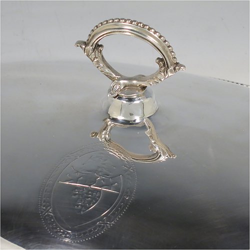 An Antique Georgian Sterling Silver pair of entree or hash dishes with covers, having oval bodies with applied bead-edged borders and cast loop side-handles, with plain domed lift-off covers having removable cast bead handles, and all sitting on flat bases. Made by Henry Green of London in 1790. The dimensions of this pair of fine hand-made antique silver entree dishes and covers are length 38 cms (15 inches), width 21.5 cms (8.5 inches), height including cover handle 11 cms (4.3 inches), and they weigh a total of approx. 2,077g (67 troy ounces). Please note that both the bases and covers are crested.