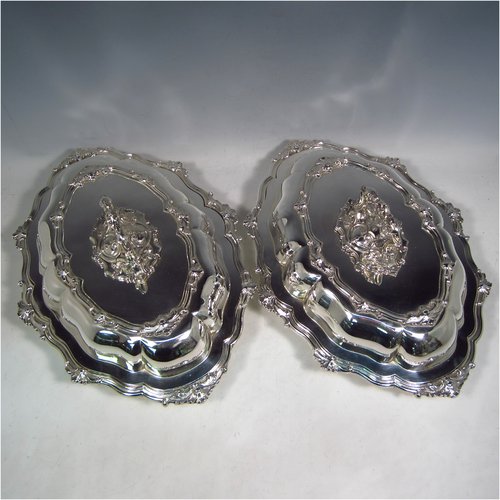 A very handsome Antique Sterling Silver pair of entree dishes, having oval lobed bodies, with lift-off lids, removable bayonet-fit handles, applied cast floral and scroll borders, and sitting on flat bases. These elegant silver entree dishes and covers were made by James Dixon & Sons of Sheffield in 1918. The dimensions of this fine pair of hand-made antique silver entree dishes and covers are length 35 cms (13.75 inches), width 26 cms (10.25 inches), and they weigh a total of approx. 3,472g (112 troy ounces).