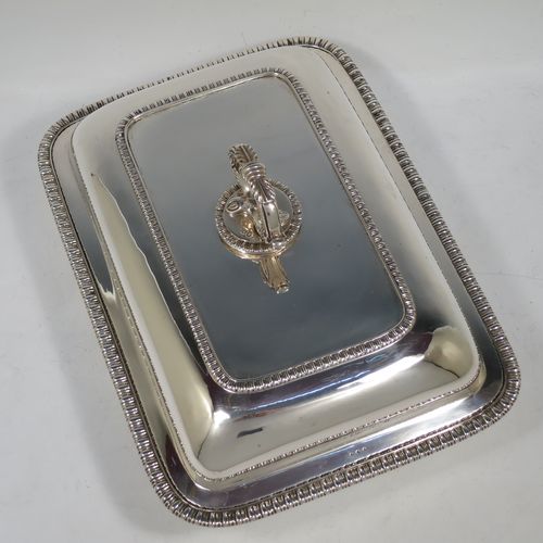 A handsome pair of Antique Georgian Sterling Silver entree dishes with covers, having rectangular bodies with rounded corners and applied gadroon borders, cast bayonet-fit removable asparagus style loop handles, and sitting on flat bases. Made by Richard Crossley of London in 1811. The dimensions of this pair of fine hand-made antique silver entree dishes and covers are length 29 cms (11.5 inches), height including handle 14 cms (5.5 inches), width 21 cms (8.25 inches), and they weigh a total of approx. 2,808g (90 troy ounces).