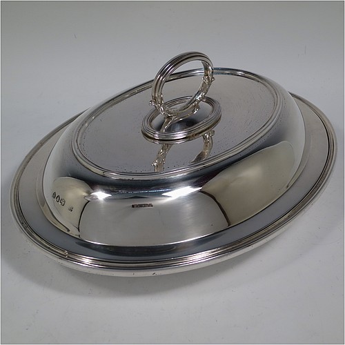An Antique Victorian Sterling Silver pair of entree dishes, having plain oval bodies, with lift-off lids, removable bayonet-fit handles, applied reeded borders, and sitting on flat bases. Made by the Savory Brothers of London in 1893. The dimensions of this fine pair of hand-made antique silver entree dishes and covers are length 29 cms (11.5 inches), width 22 cms (8.75 inches), and they weigh a total of approx. 3,472g (112 troy ounces).