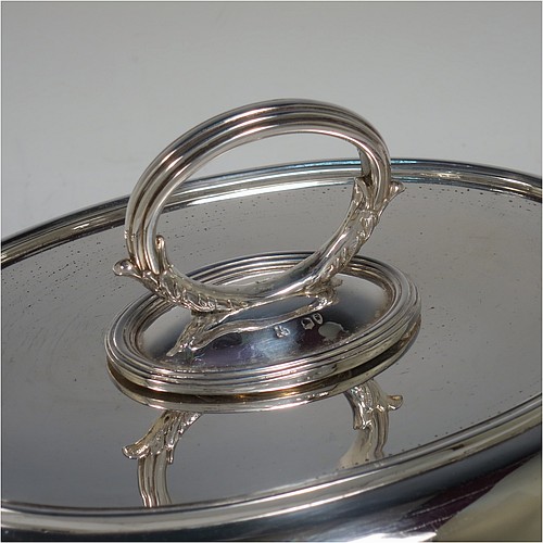 An Antique Victorian Sterling Silver pair of entree dishes, having plain oval bodies, with lift-off lids, removable bayonet-fit handles, applied reeded borders, and sitting on flat bases. Made by the Savory Brothers of London in 1893. The dimensions of this fine pair of hand-made antique silver entree dishes and covers are length 29 cms (11.5 inches), width 22 cms (8.75 inches), and they weigh a total of approx. 3,472g (112 troy ounces).