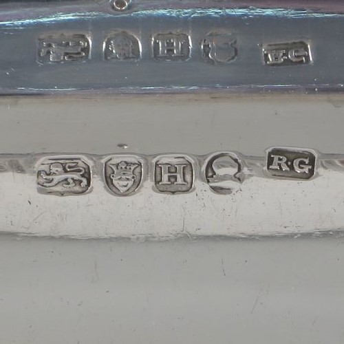 A very handsome and heavy pair of Antique Georgian Sterling Silver entree dishes with covers, having rectangular bodies with rounded corners and applied gadroon borders, cast screw-fit removable asparagus style loop handles, and sitting on flat bases. Made by Robert Garrard of London in 1803. The dimensions of this pair of fine hand-made antique silver entree dishes and covers are length 28.5 cms (11.25 inches), height including handle 12 cms (4.75 inches), width 22 cms (8.75 inches), and they weigh a total of approx. 3,220g (104 troy ounces). Please note that these items are crested.