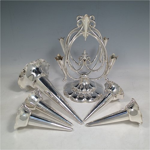 An Antique Victorian Silver Plated Art Nouveau flower vase epergne center-piece, having five removable flower vases, with a central larger vase, all sitting on a base with wire-work scrolls and melon-style fluting. All made in ca. 1890. The dimensions of this fine hand-made silver-plated flower epergne are height 37 cms (14.5 inches), and spread across vases 28 cms (11 inches).