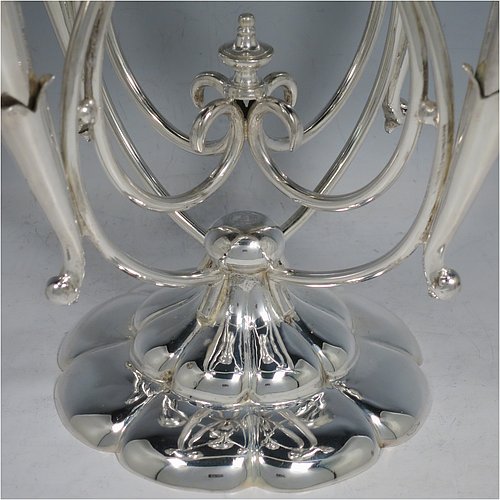 An Antique Victorian Silver Plated Art Nouveau flower vase epergne center-piece, having five removable flower vases, with a central larger vase, all sitting on a base with wire-work scrolls and melon-style fluting. All made in ca. 1890. The dimensions of this fine hand-made silver-plated flower epergne are height 37 cms (14.5 inches), and spread across vases 28 cms (11 inches).