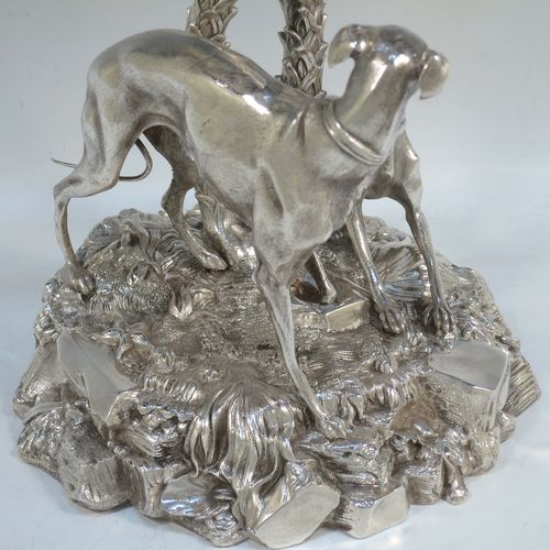 A very handsome Antique Victorian silver-plated table palm tree center-piece, having two palm trees inter-twined with a total of seven fronds, standing underneath which are two cast models of playful greyhounds or lurchers, and all sitting on a round naturalistic cast rock base. Made by Elkington and Co. with a date letter mark for 1852. The dimensions of this fine hand-made silver-plated table centerpiece display are height 41 cms (16 inches), spread across fronds 31 cms (12.25 inches), and diameter at base 20 cms (8 inches).

  
