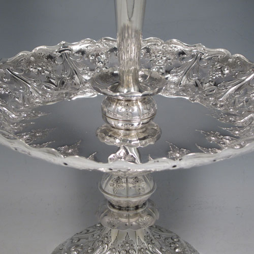 Antique Victorian sterling silver epergne flower vase centerpiece, having a central flower vase with hand-cut crystal holder, a hand-chased dish surrounding the latter with fruit and floral decoration, all sitting on a pedestal foot with matching hand-chased work. Made by Martin and Hall of London in 1881. The dimensions of this fine hand-made silver center-piece are height 47 cms (18.5 cms), diameter 23.5 cms (9.25 inches), and it weighs approx. 788g (25.3 troy ounces).