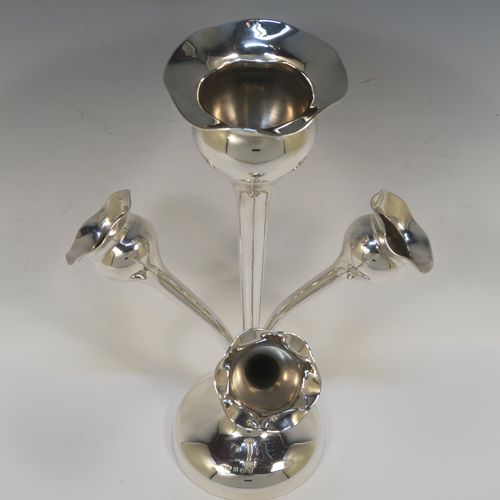 A pretty Antique Sterling Silver flower vase epergne center-piece in a plain round style, having three removable side flower vases that slot into the base of a central larger vase, and all sitting on a plain round pedestal foot. This beautiful antique silver flower epergne was made by Joseph Gloster of Birmingham in 1916. The dimensions of this fine hand-made sterling silver flower centre-piece epergne are height 29.5 cms (11.5 inches), spread across vases 19 cms (7.5 inches), and it weighs approx. 435g (14 troy ounces).   