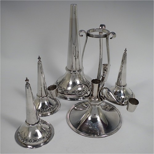 A Sterling Silver flower vase epergne center-piece, having four removable flower vases with hand-pierced top borders, with a central larger vase and three smaller side vases, all sitting on a pedestal base with wire-work scroll holders and applied reed-edged borders. Made by Henry Matthews of Birmingham in 1922. The dimensions of this fine hand-made sterling silver flower epergne are height 28 cms (11 inches), spread across vases 24 cms (9.5 inches), and it weighs approx. 645g (21 troy ounces).