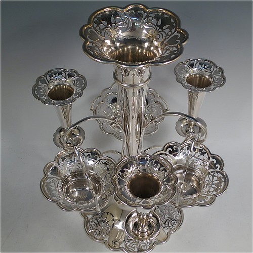 A very pretty Antique Edwardian Art Nouveau Sterling Silver table Epergne centrepiece, having a central large flower vase surrounded by three smaller vases and three removable swing-handled bowls, all with hand-pierced floral decoration, and sitting on a spreading lobed foot. Made by Fattorini and Sons of Birmingham in 1910/11. The dimensions of this fine hand-made antique silver Epergne table centrepiece are height 38.5 cms (15 inches), width 29 cms (11.5 inches), and it weighs a total of approx. 1,708g (55 troy ounces)