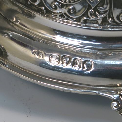 A very pretty Antique Victorian Sterling Silver table Epergne centrepiece, having a central cut crystal flower vase mounted above a matching round fruit bowl, all sitting on a lower silver body with hand-chased floral decoration, and three cast foliate feet. This beautiful silver and crystal epergne was made by Steven Smiley of London in 1876. The dimensions of this fine hand-made antique silver and crystal Epergne table centerpiece are height 53 cms (21 inches), and diameter of bowl 27 cms (10.5 inches),   