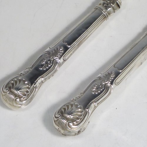 Antique early Victorian sterling silver fish serving knife and fork set, having filled handles in the double-struck Kings pattern, hand-pierced and hand-engraved blade and tines with floral and leaf decoration, the blade with a cartouche engraved with a lady holding a tray of fish. Made by Francis Higgins of London in 1849. The dimensions of this fine hand-made silver fish serving set are length of knife 33 cms (13 inches), and length of fork 24 cms (9.5 inches). Please note that the handles have a number of small dents, but are otherwise in very good condition.