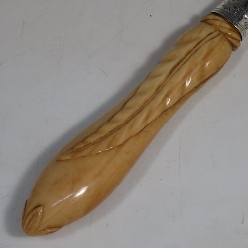 An Antique Victorian sterling silver and ivory-handled fish server slice, having a hand-cut ivory handle with leaf decoration, a hand-pierced symmetrical blade with floral decoration and an engraved scene of a fisherman on one side, together with a silver ferrule between the blade and handle. Made by George Unite of Birmingham in 1872. The length of this fine hand-made antique silver fish serving slice is 31 cms (12.25 inches).