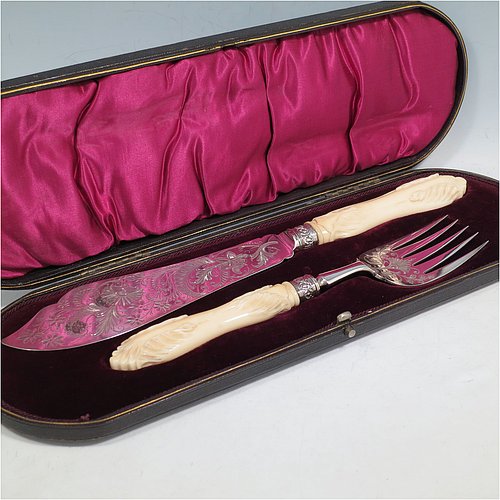 An Antique Victorian Sterling Silver fish serving knife and fork set, having hand-carved bone handles, with hand-engraved blade and tines with floral decoration, all in their original maroon satin and velvet-lined presentation box. Made by Robert Fead Mosley of Sheffield in 1894. The dimensions of this fine hand-made antique silver and bone-handled fish serving set are length of knife 32 cms (12.5 inches), and length of fork 24 cms (9.5 inches).   