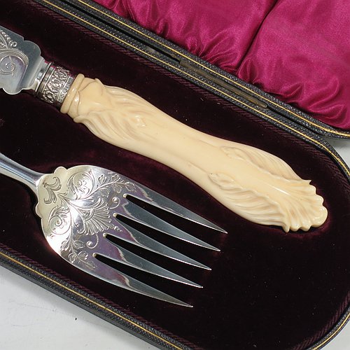 An Antique Victorian Sterling Silver fish serving knife and fork set, having hand-carved bone handles, with hand-engraved blade and tines with floral decoration, all in their original maroon satin and velvet-lined presentation box. Made by Robert Fead Mosley of Sheffield in 1894. The dimensions of this fine hand-made antique silver and bone-handled fish serving set are length of knife 32 cms (12.5 inches), and length of fork 24 cms (9.5 inches).   