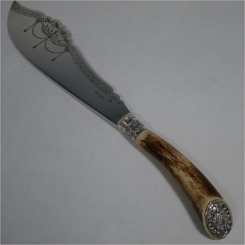 An Antique Edwardian Sterling Silver and Silver-Plated fish serving knife and fork set, having hand-carved antler bone handles that have hallmarked silver ferrules and end caps, with hand-engraved silver plated blade and tines with floral decoration, all in their original cream satin and dark blue velvet-lined presentation box. Made by Edward Smith of Sheffield in 1909. The dimensions of this fine hand-made antique silver and bone-handled fish serving set are length of knife 33 cms (13 inches), and length of fork 25 cms (9.75 inches).