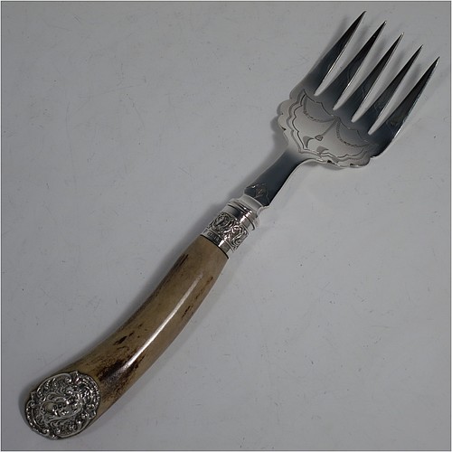 An Antique Edwardian Sterling Silver and Silver-Plated fish serving knife and fork set, having hand-carved antler bone handles that have hallmarked silver ferrules and end caps, with hand-engraved silver plated blade and tines with floral decoration, all in their original cream satin and dark blue velvet-lined presentation box. Made by Edward Smith of Sheffield in 1909. The dimensions of this fine hand-made antique silver and bone-handled fish serving set are length of knife 33 cms (13 inches), and length of fork 25 cms (9.75 inches).