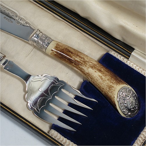 An Antique Edwardian Sterling Silver and Silver-Plated fish serving knife and fork set, having hand-carved antler bone handles that have hallmarked silver ferrules and end caps, with hand-engraved silver plated blade and tines with floral decoration, all in their original cream satin and dark blue velvet-lined presentation box. Made by Edward Smith of Sheffield in 1909. The dimensions of this fine hand-made antique silver and bone-handled fish serving set are length of knife 33 cms (13 inches), and length of fork 25 cms (9.75 inches).