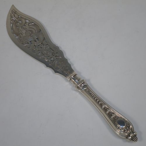 A very pretty Antique Victorian Sterling Silver pair of fish serving knife and fork set, having handles in a double-struck floral pattern with reeded sides, and hand-pierced blade and tines with hand-engraved dolphins, scroll, and floral decoration, all in their original dark blue velvet and cream satin lined presentation box. Made by Martin Hall and Co., of Sheffield in 1859. The dimensions of this fine hand-made antique silver fish serving set are length of knife 33 cms (13 inches), length of fork 25.5 cms (10 inches), and they weigh a total of approx. 300g (9.7 troy ounces).  