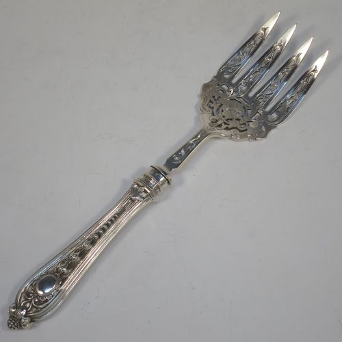 A very pretty Antique Victorian Sterling Silver pair of fish serving knife and fork set, having handles in a double-struck floral pattern with reeded sides, and hand-pierced blade and tines with hand-engraved dolphins, scroll, and floral decoration, all in their original dark blue velvet and cream satin lined presentation box. Made by Martin Hall and Co., of Sheffield in 1859. The dimensions of this fine hand-made antique silver fish serving set are length of knife 33 cms (13 inches), length of fork 25.5 cms (10 inches), and they weigh a total of approx. 300g (9.7 troy ounces).  