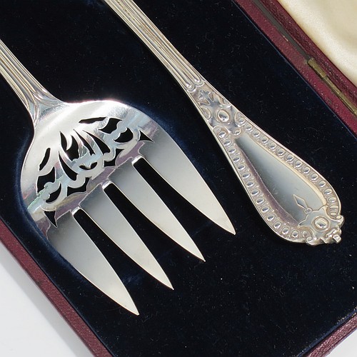 An Antique Victorian Sterling Silver pair of fish serving knife and fork set, having solid handles in the double-struck Victorian Bead pattern, with reeded handles, and hand-pierced blade and tines with floral decoration, all in their original blue velvet and cream satin lined presentation box. Made by George Adams of London in 1862. The dimensions of this fine hand-made antique silver fish serving set are length of knife 31 cms (12.75 inches), length of fork 25.5 cms (10 inches), and they weigh a total of 320g (10.3 troy ounces).   
