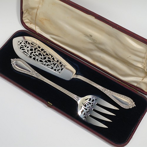 An Antique Victorian Sterling Silver pair of fish serving knife and fork set, having solid handles in the double-struck Victorian Bead pattern, with reeded handles, and hand-pierced blade and tines with floral decoration, all in their original blue velvet and cream satin lined presentation box. Made by George Adams of London in 1862. The dimensions of this fine hand-made antique silver fish serving set are length of knife 31 cms (12.75 inches), length of fork 25.5 cms (10 inches), and they weigh a total of 320g (10.3 troy ounces).   