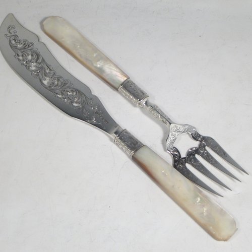 Antique Victorian sterling silver fish serving knife and fork set, having hand-carved mother-of-pearl handles, with hand-pierced and hand-engraved blade and tines with floral decoration. Made by Foxall & Co., of London in 1852. The dimensions of this fine hand-made silver fish serving set are length of knife 32 cms (12.5 inches), and length of fork 25.5 cms (10 inches).   