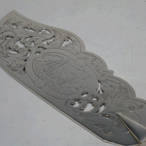 A very pretty Antique Victorian Sterling Silver fish serving knife and fork set, having handles in the double-struck Queens pattern, hand-pierced and hand-engraved with floral and leaf decoration, the blade with a cartouche engraved with a scene of a sea fishing vessel. Made by Thomas Hart Stone of Exeter in 1865. The dimensions of this fine hand-made antique silver fish serving set are length of knife 31 cms (12.25 inches), length of fork 25.5 cms (10 inches), and a total weight of 300g (9.7 troy ounces).
