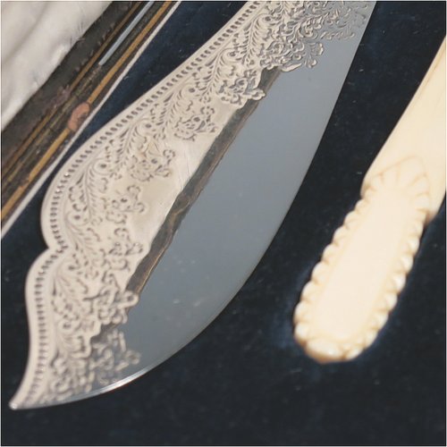 An Antique Victorian Sterling Silver fish serving knife and fork set, having hand-carved bone or ivory handles, with hand-engraved blade and tines with floral decoration, all in their original satin and blue velvet-lined presentation box. Made by James Deakin & Sons of Sheffield in 1887. The dimensions of this fine hand-made antique silver fish serving set are length of knife 31 cms (12.25 inches), and length of fork 24 cms (9.5 inches). Please note that the cream coloured satin upper lining to the lid is slightly damaged.