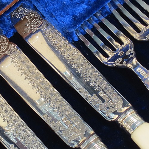 A very pretty Antique Victorian Sterling Silver and bone-handled fish set for twelve people, having hand-engraved blades and tines with floral decoration, and fitted into their original dark blue velvet and satin-lined oak presentation box. All made by Henry Atkins of Sheffield in 1896. The dimensions of these fine hand-made antique silver fish-eaters are length of knife 21.5 cms (8.5 inches), and fork 18.5 cms (7.25 inches).    
