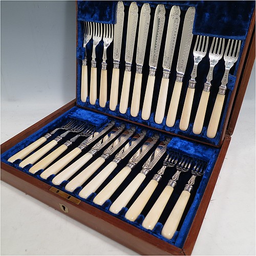 A very pretty Antique Victorian Sterling Silver and bone-handled fish set for twelve people, having hand-engraved blades and tines with floral decoration, and fitted into their original dark blue velvet and satin-lined oak presentation box. All made by Henry Atkins of Sheffield in 1896. The dimensions of these fine hand-made antique silver fish-eaters are length of knife 21.5 cms (8.5 inches), and fork 18.5 cms (7.25 inches).    